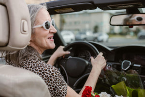 Lady driving a convertible.