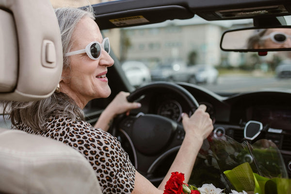 Lady driving a convertible.