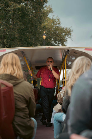 Tour operator speaking into a mic on a bus tour.