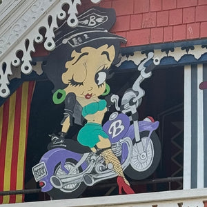 Cartoon character riding a scooter, representing fun and adventure in the context of exploring vineyards and villages in the Niagara Region.