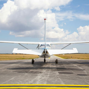 Cessna aircraft on runway with blue sky and clouds, representing adventure and exploration for Mystery Day Trips in Ontario.