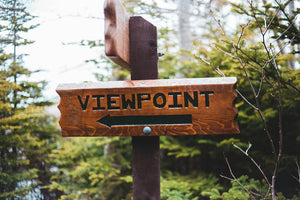 Wooden sign pointing to a viewpoint with trees in the background. Representing Mystery Day Trips 100+ hidden gems in its trip library.