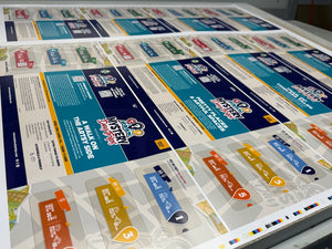 Sheet of printed Mystery Day Trip product with colourful design elements awaiting to be bound into peel-to-reveal cards.