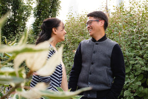 Couple laughing in a garden while on a spontaneous Mystery Day Trip.