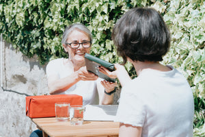 Woman accepting a wrapped gift from a friend.
